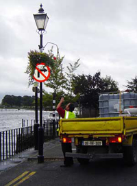 Athlone city council employee watering flowers in the rain