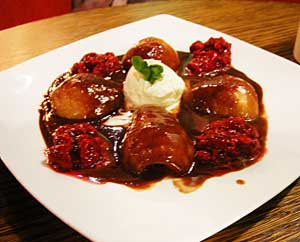 Blanched pears in chocolate sauce with raspberries on a white, square-cornered dinner plate in Divertamento restaurant, Athlone